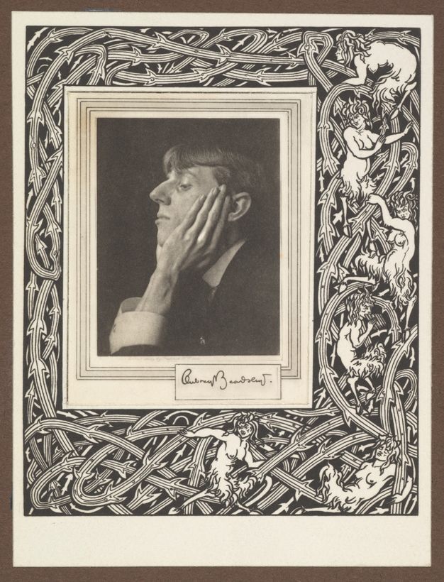 Photogravure. A clean shaven man with a prominent, curving nose faces our left in profile against a dark background. He rests his chin in his hands, and one long-fingered hand lies up along his cheek. The portrait is set in a printed border of interwoven, thorny vines and several creatures with women’s heads and torsos and goats’ legs.