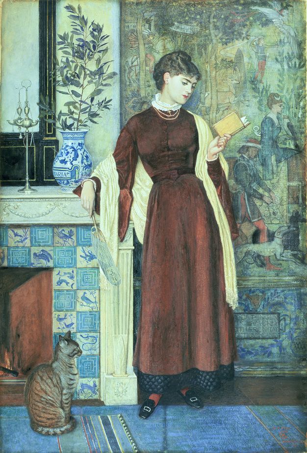Painting. A pale-skinned woman wearing a long mahogany-red dress stands with one arm resting on a fireplace mantle as she looks at a small book held up in her other hand. A striped tabby cat sits near her feet, its paws tucked close to its body. A tapestry or painting behind the woman shows people in a landscape.
